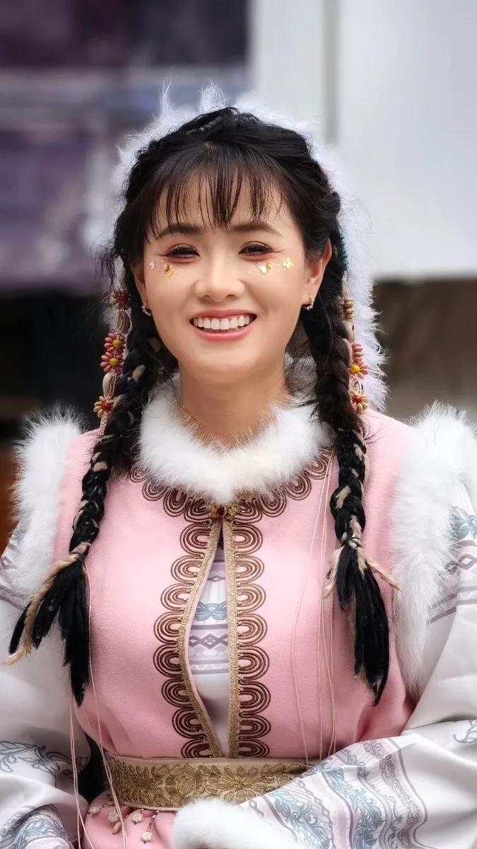 Portrait einer lächelnden Frau in traditioneller Naxi-Tracht