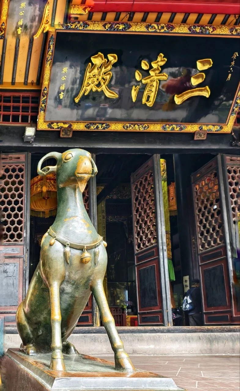 Tempelfassade mit goldenem Schild und Bronzestatue