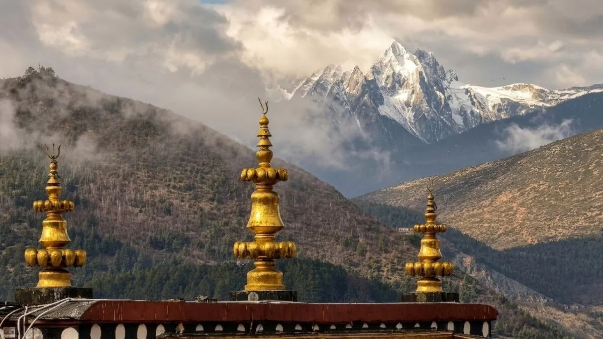 Goldene Tempelspitzen vor einem schneebedeckten Bergmassiv