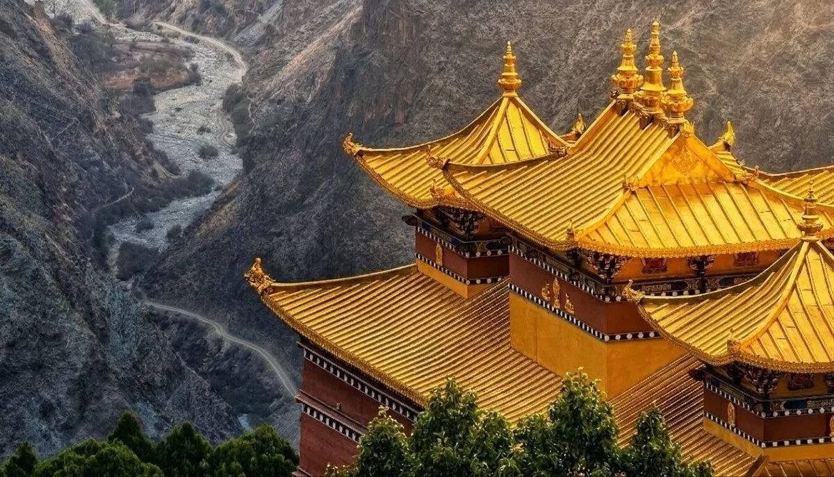 Blick über goldene Tempeldächer auf den Jinsha-Fluss in der Schlucht