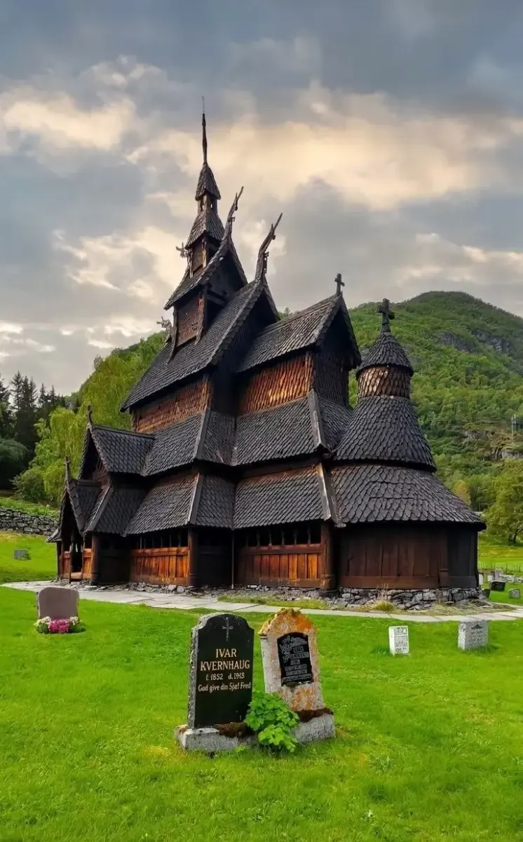 Stabkirche von Borgund mit Friedhof unter dunklem Himmel